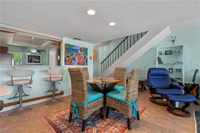 dining room featuring a textured ceiling, ceiling fan, and light tile patterned flooring