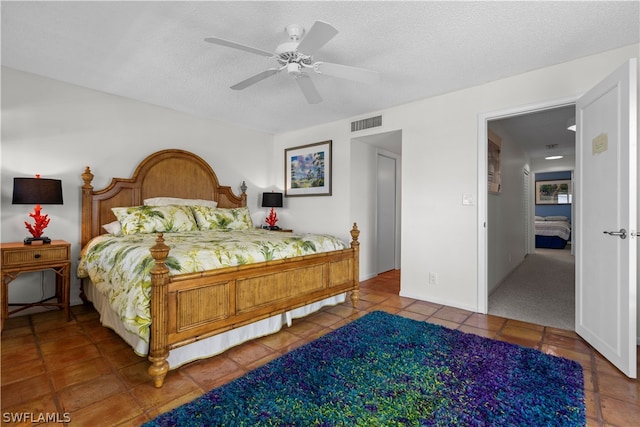 carpeted bedroom with ceiling fan and a textured ceiling