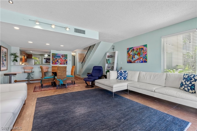 living room featuring a textured ceiling and dark tile patterned floors