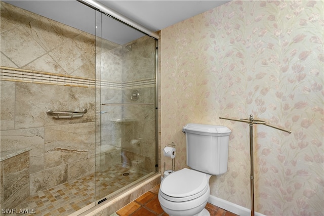 bathroom with tile patterned floors, toilet, and a shower with door