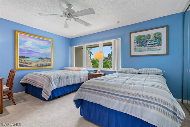 bedroom featuring carpet, a textured ceiling, and ceiling fan