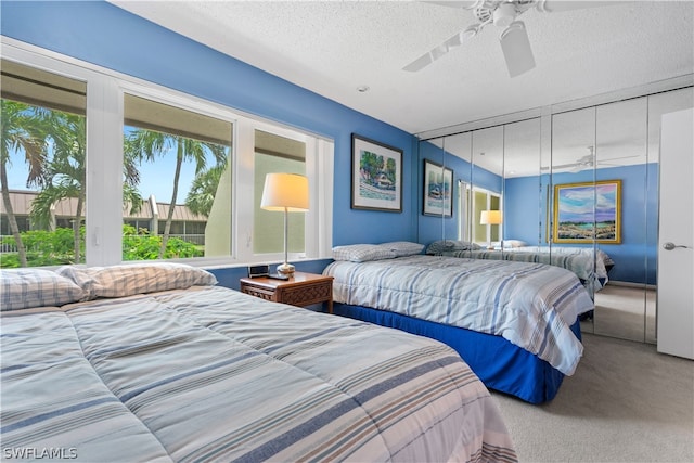 bedroom featuring ceiling fan, a textured ceiling, and carpet flooring