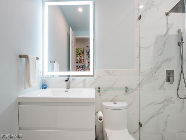 bathroom with vanity, tiled shower, tile walls, and toilet