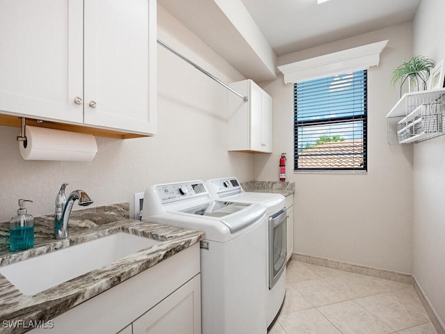 laundry room featuring cabinets, independent washer and dryer, sink, and light tile patterned floors