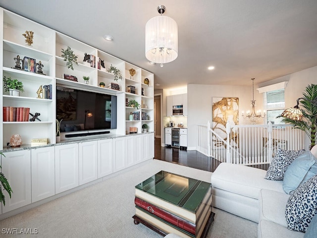 carpeted living room with a chandelier