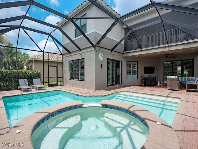 view of swimming pool with a patio area, glass enclosure, an in ground hot tub, ceiling fan, and an outdoor living space