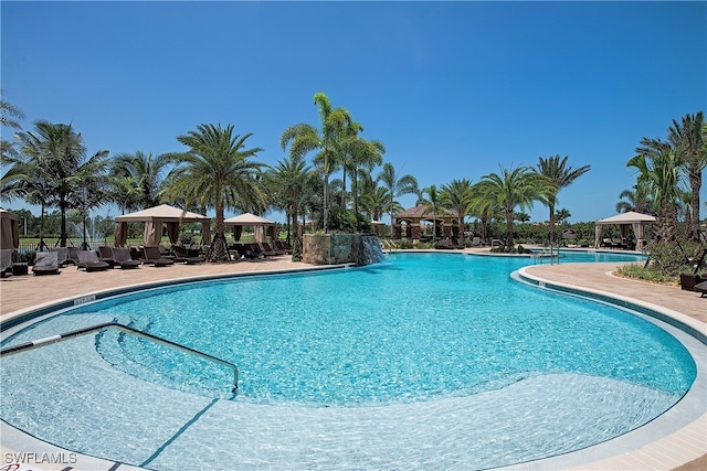 view of swimming pool with a patio, a gazebo, and pool water feature