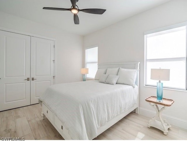 bedroom with ceiling fan, a closet, and light hardwood / wood-style floors