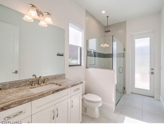 bathroom featuring tile patterned floors, vanity, toilet, and a shower with shower door