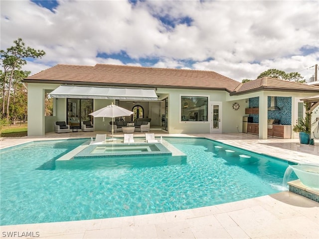 view of pool featuring an outdoor living space, pool water feature, an in ground hot tub, exterior kitchen, and a patio