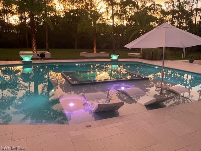 view of pool with a lawn, a jacuzzi, and a patio