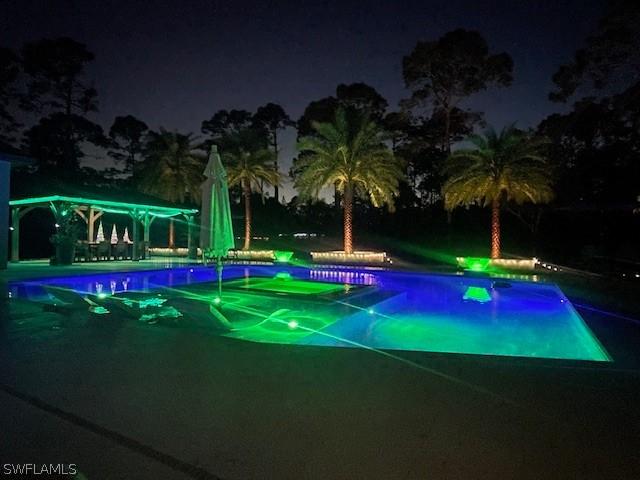 view of pool at twilight