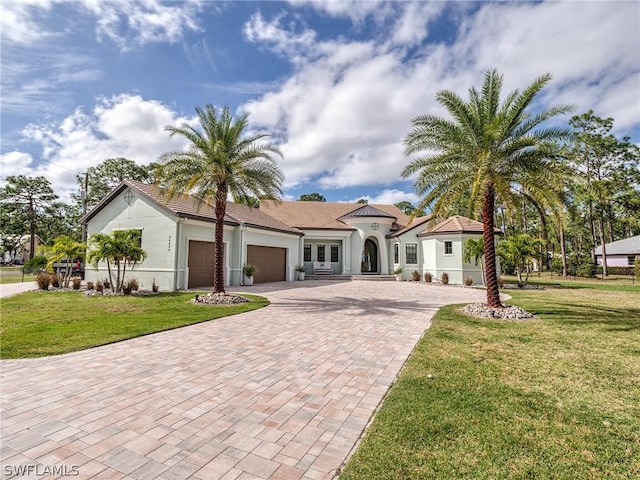 mediterranean / spanish-style home featuring a front yard and french doors