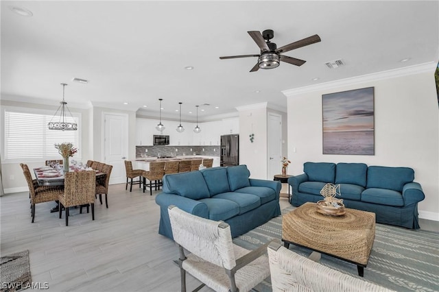 living room with ceiling fan and crown molding