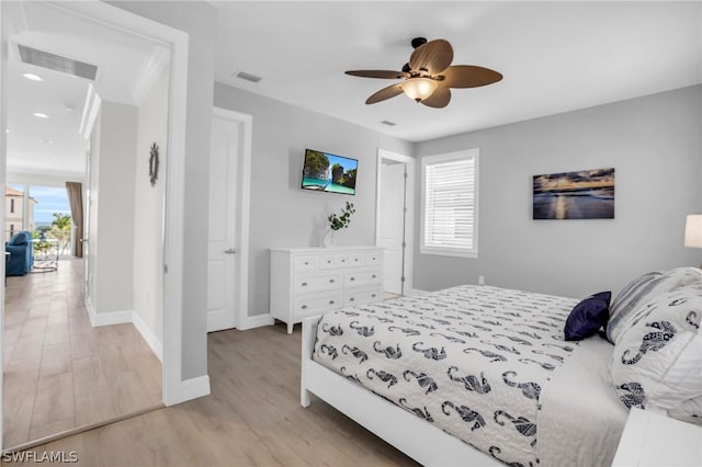 bedroom with multiple windows, light hardwood / wood-style floors, and ceiling fan