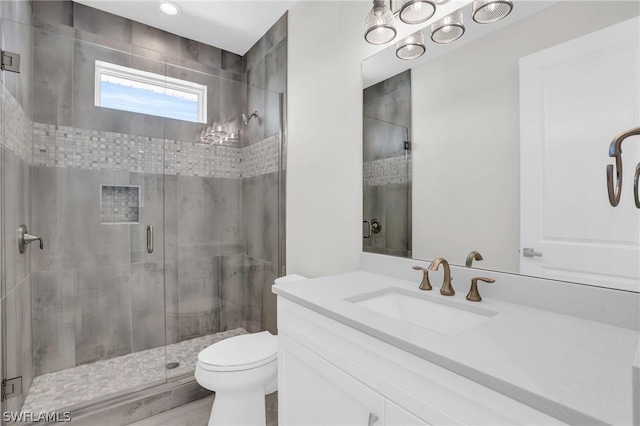 bathroom featuring toilet, an enclosed shower, and vanity