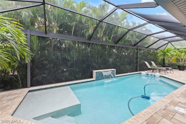 view of swimming pool featuring pool water feature, a patio, and a lanai