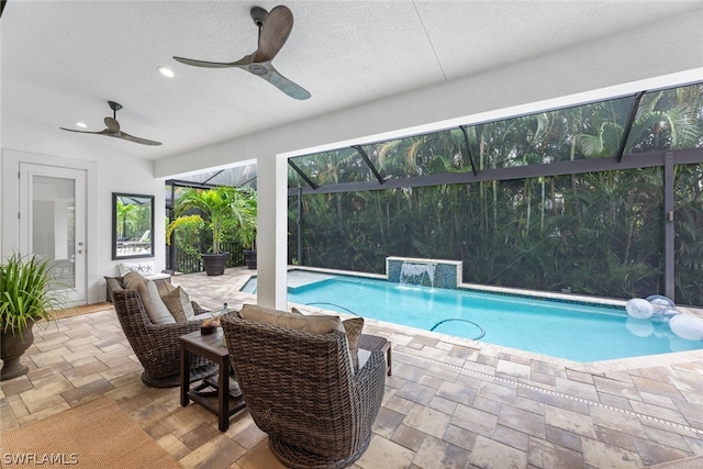 view of pool featuring a lanai, pool water feature, a patio, and ceiling fan