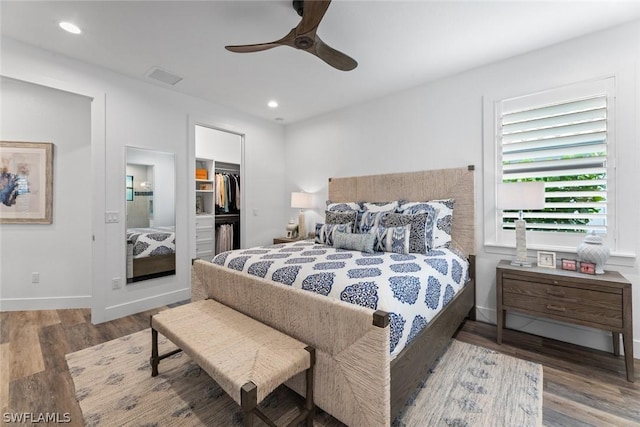 bedroom featuring recessed lighting, wood finished floors, visible vents, a spacious closet, and a closet