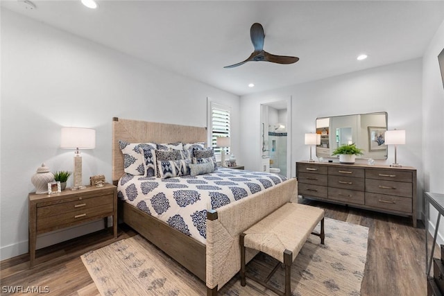 bedroom featuring baseboards, a ceiling fan, wood finished floors, ensuite bathroom, and recessed lighting