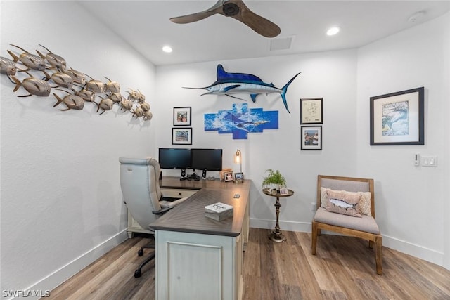 office area with a ceiling fan, wood finished floors, visible vents, and baseboards