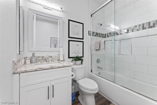 bathroom featuring combined bath / shower with glass door, vanity, toilet, and wood finished floors