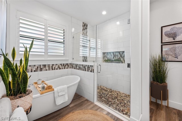 bathroom featuring hardwood / wood-style floors, a healthy amount of sunlight, and separate shower and tub