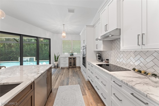 kitchen featuring white cabinetry, dishwashing machine, tasteful backsplash, exhaust hood, and hardwood / wood-style flooring