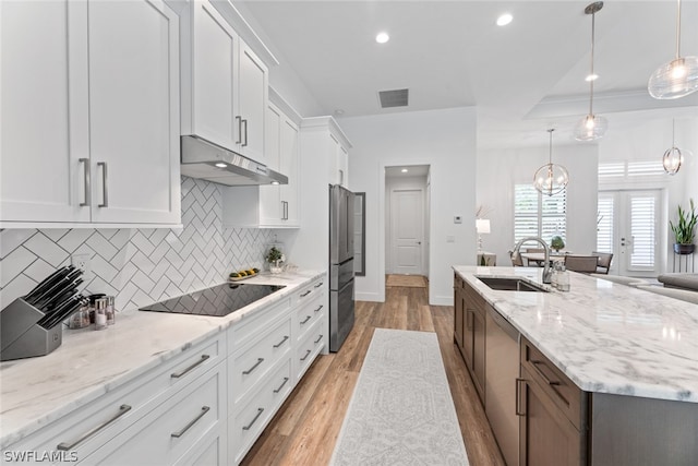 kitchen featuring white cabinetry, hanging light fixtures, hardwood / wood-style floors, and sink