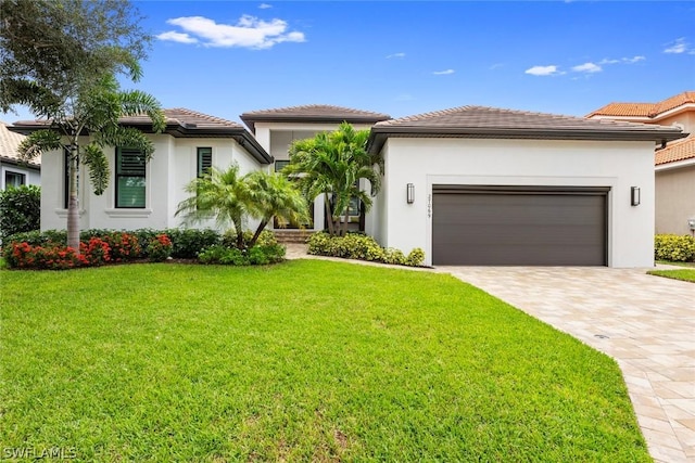 view of front facade featuring an attached garage, a front lawn, decorative driveway, and stucco siding