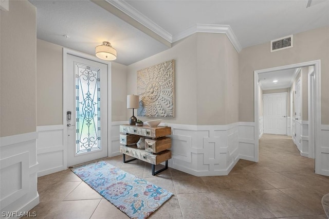 entrance foyer with crown molding and light tile patterned floors