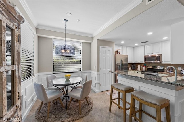 dining room featuring ornamental molding, sink, and light tile patterned floors