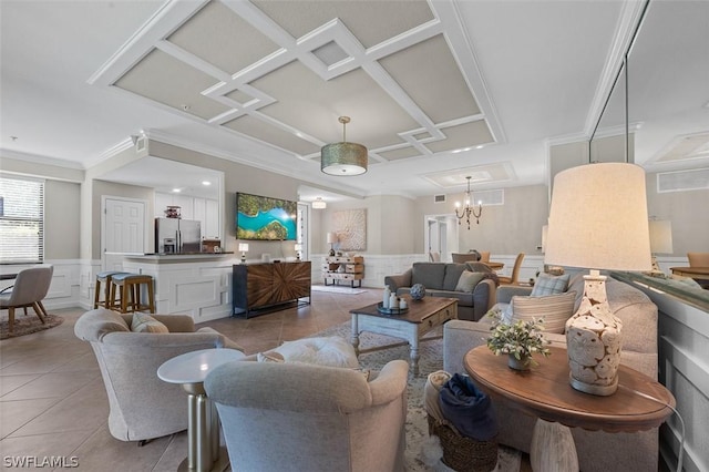 tiled living room featuring ornamental molding, coffered ceiling, and a notable chandelier