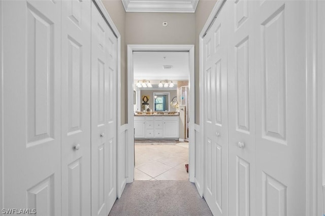 hallway featuring crown molding and light colored carpet