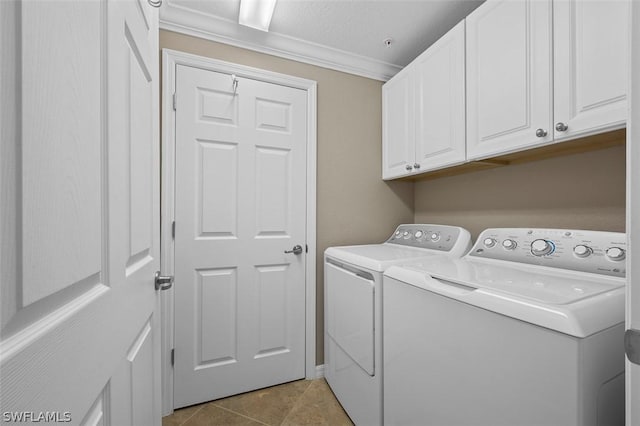 clothes washing area featuring cabinets, ornamental molding, washer and dryer, and light tile patterned flooring