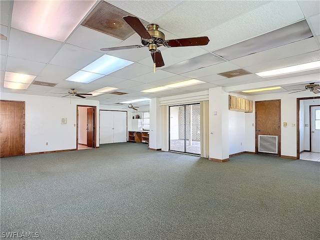 carpeted spare room featuring a drop ceiling