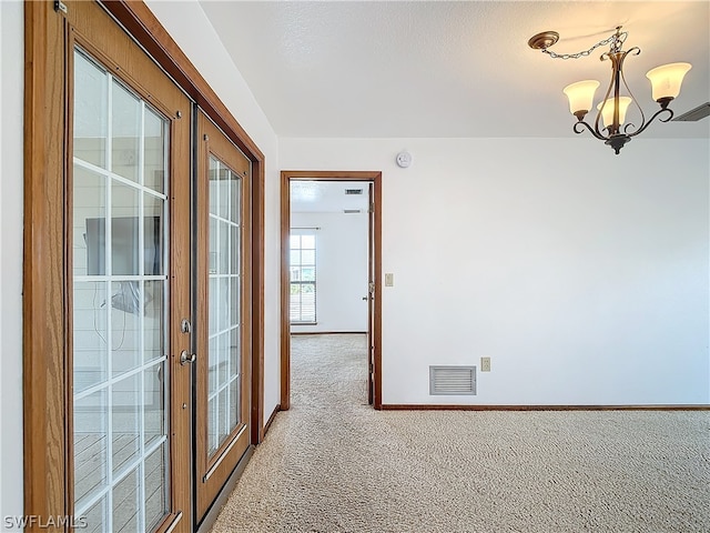 interior space featuring a chandelier, light carpet, and french doors