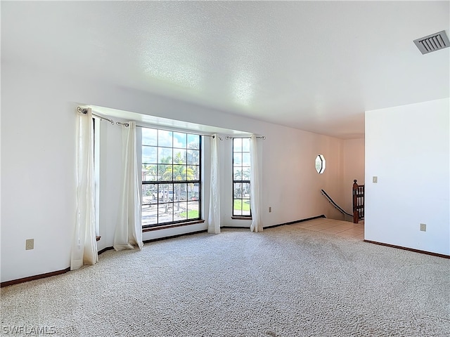 carpeted spare room featuring a textured ceiling