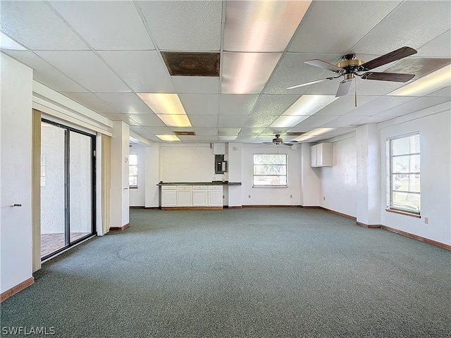 spare room with ceiling fan, a drop ceiling, and carpet floors