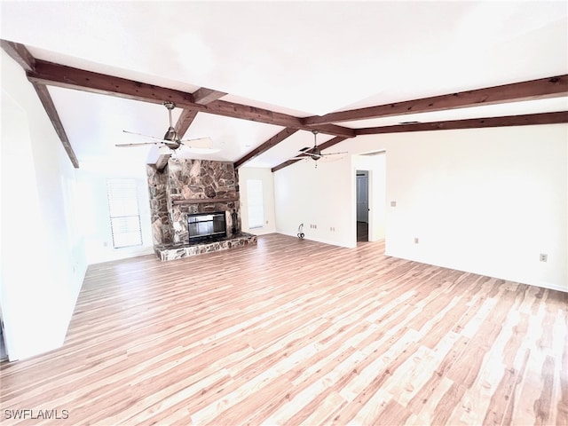 unfurnished living room with light hardwood / wood-style floors, a stone fireplace, vaulted ceiling with beams, and ceiling fan