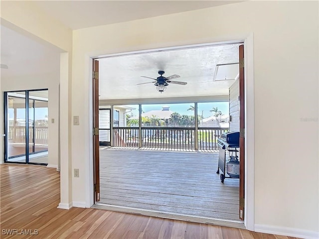 24313 Pirate Harbor Blvd, Punta Gorda, FL 33955 - doorway featuring baseboards, a ceiling fan, wood finished floors, and a healthy amount of sunlight
