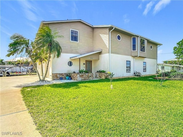 24313 Pirate Harbor Blvd, Punta Gorda, FL 33955 - view of front of home featuring stucco siding, driveway, and a front yard