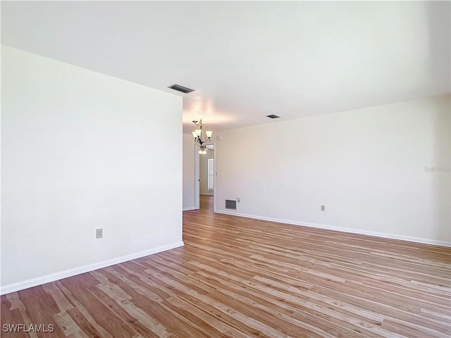 24313 Pirate Harbor Blvd, Punta Gorda, FL 33955 - unfurnished room with baseboards, a notable chandelier, visible vents, and light wood-style flooring