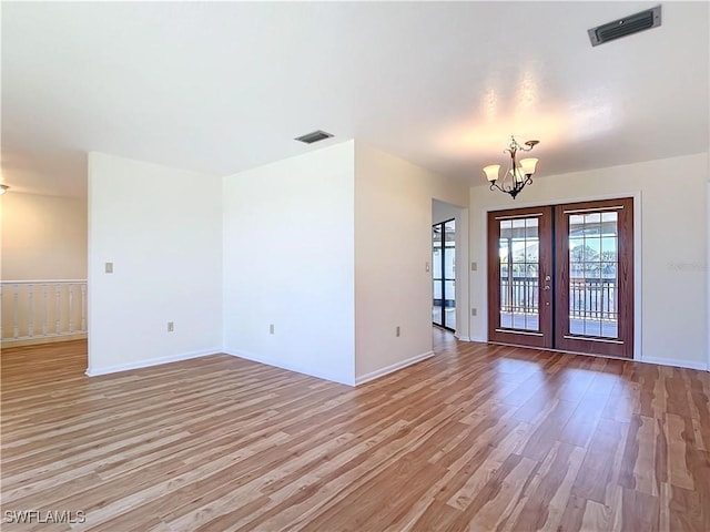 24313 Pirate Harbor Blvd, Punta Gorda, FL 33955 - spare room with an inviting chandelier, french doors, light wood-style floors, and visible vents