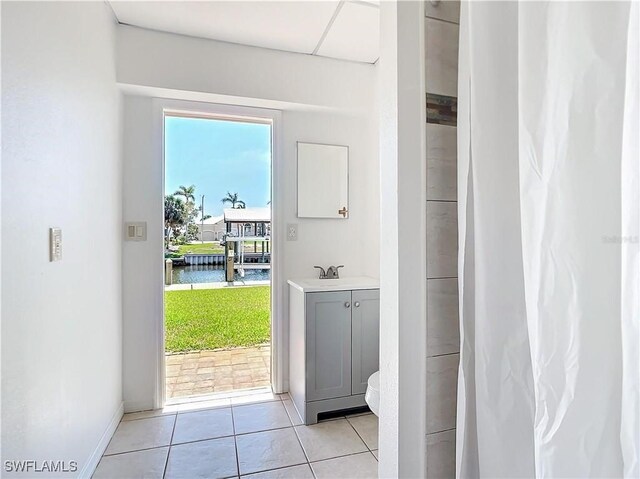 24313 Pirate Harbor Blvd, Punta Gorda, FL 33955 - doorway to outside featuring a water view, baseboards, and light tile patterned floors