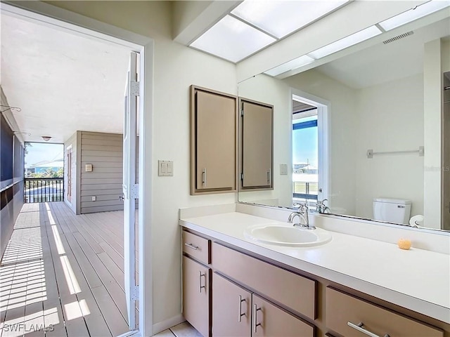 24313 Pirate Harbor Blvd, Punta Gorda, FL 33955 - bathroom with a wealth of natural light, toilet, vanity, and visible vents