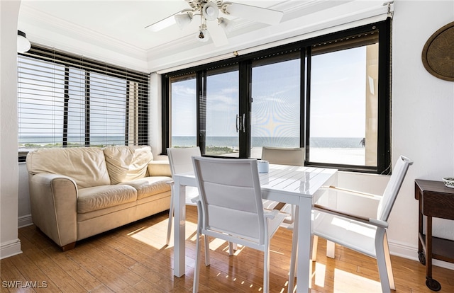 dining area with a wealth of natural light, crown molding, and wood finished floors