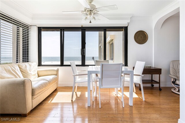 dining space with light wood-type flooring, ornamental molding, and ceiling fan