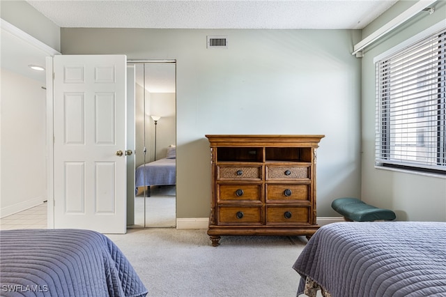 bedroom featuring a closet and light colored carpet