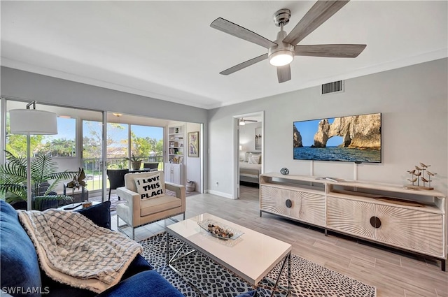 living room featuring ceiling fan and ornamental molding